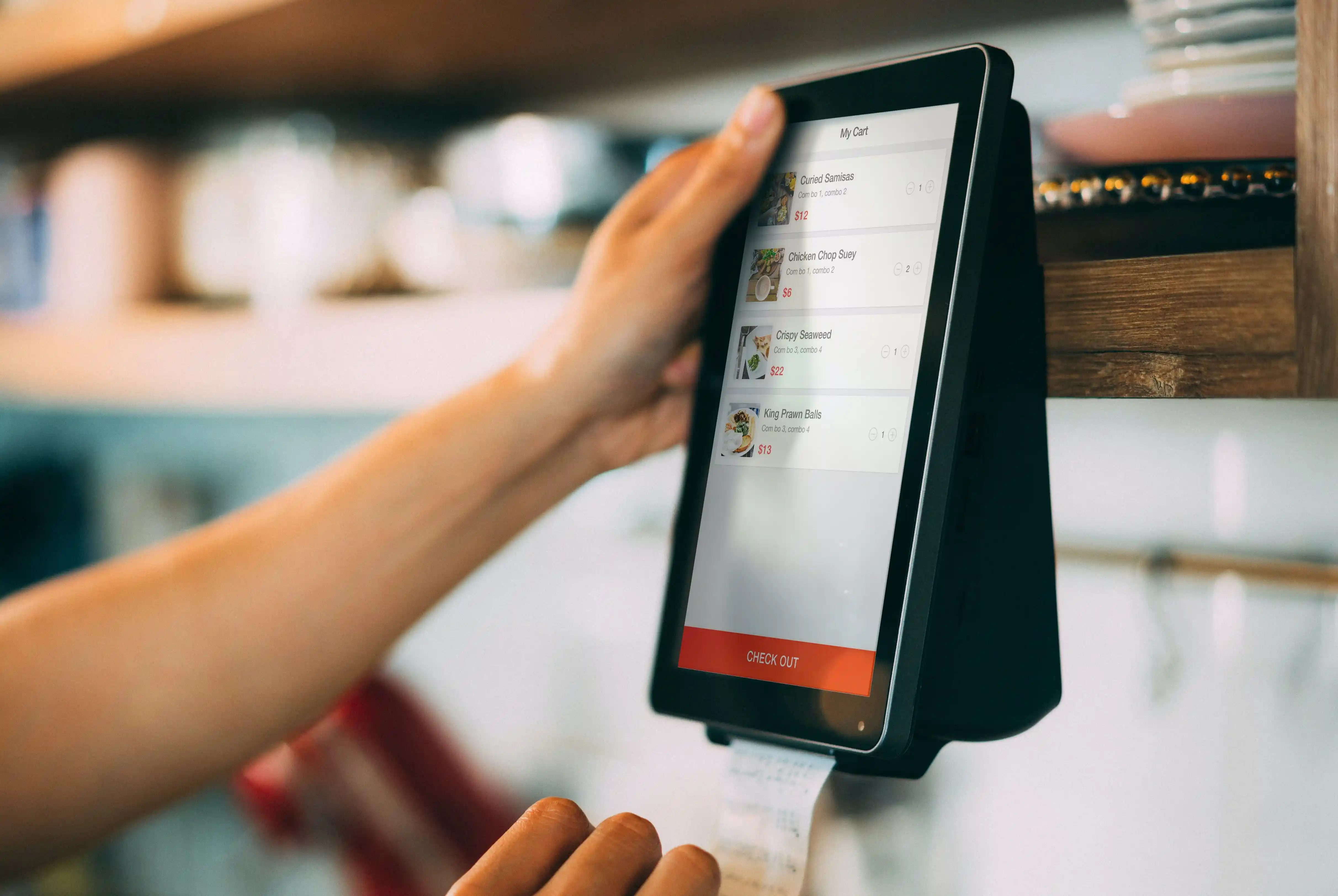A touchscreen POS terminal printing a receipt